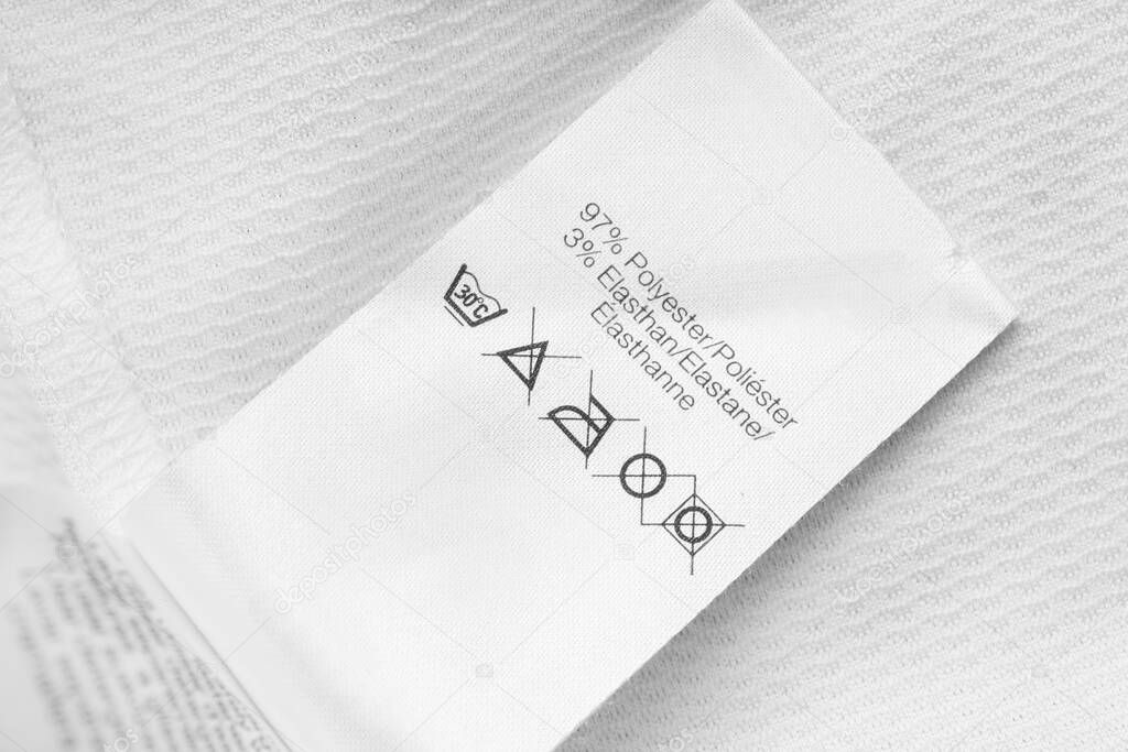 Care and fabric composition clothing label on white textile background
