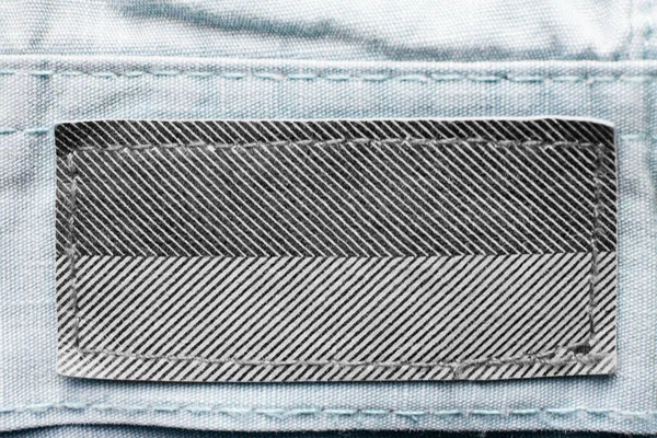 Etiqueta Ropa Blanco Negro Sobre Fondo Textil Azul — Foto de Stock