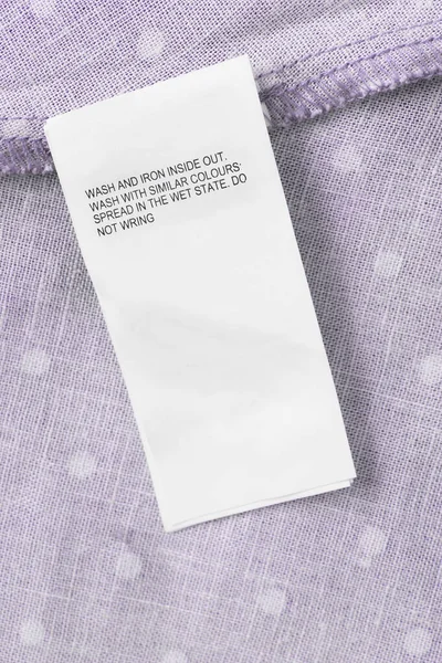 Care clothing label on purple textile background