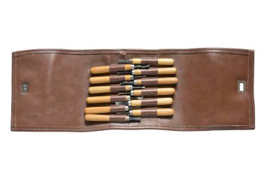 Deri çantadaki oyma aletleri beyazın üzerine izole edilmiş.