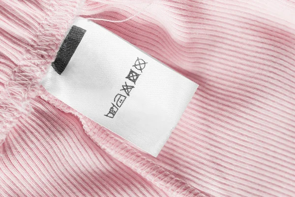 Etykieta Odzieży Pielęgnacyjnej Różowym Tle Bawełny — Zdjęcie stockowe