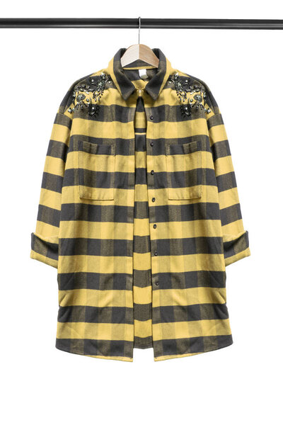 Black and yellow jacket hanging on wooden clothes rack isolated over white