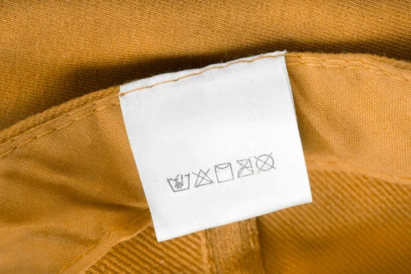 Etykieta Odzieży Pielęgnacyjnej Żółtym Tle Włókienniczym — Zdjęcie stockowe