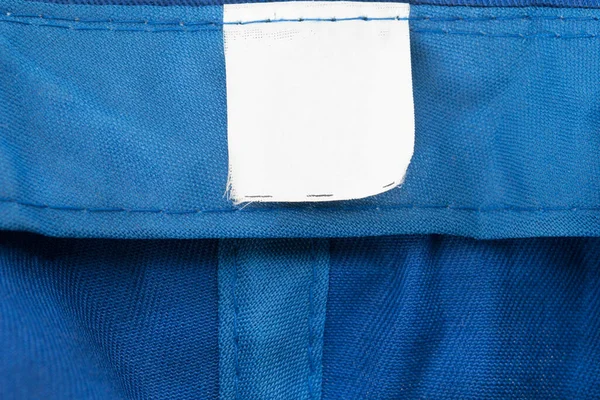 Etiqueta Ropa Blanco Sobre Fondo Textil Azul — Foto de Stock