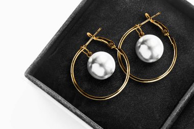 Zarif inci küpeler siyah mücevher kutusunda.