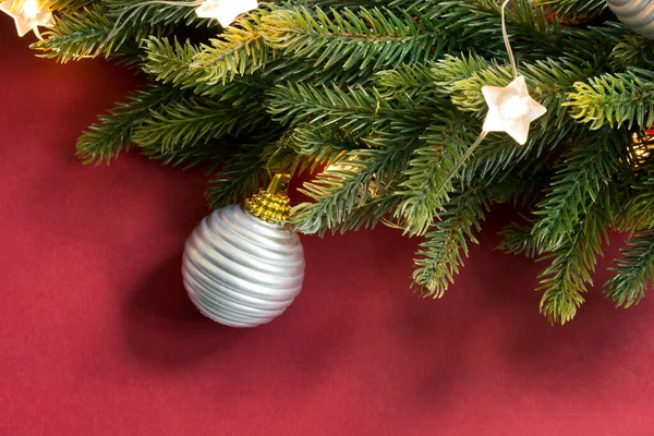 Kerstboom Tak Met Verlichting Een Bal Close Rode Achtergrond — Stockfoto