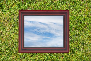 Ahşap fotoğraf çerçevesi yeşil çim duvar arka planda gökyüzü, manzaralı.