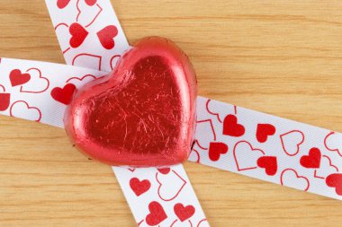 ahşap zemin üzerine çikolata şeker kırmızı kalp.