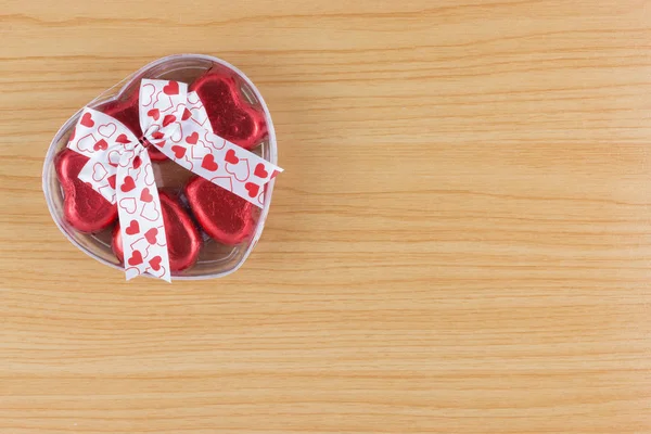 巧克力糖果红色的心在礼品盒与丝带在木背上 — 图库照片
