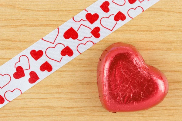 Čokoládové bonbóny červené srdce na dřevěné pozadí. — Stock fotografie