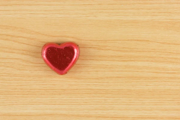 Čokoládové bonbóny červené srdce na dřevěné pozadí. — Stock fotografie