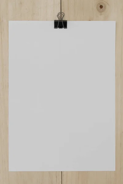 Papel branco com clipe de papel sobre fundo de madeira . — Fotografia de Stock