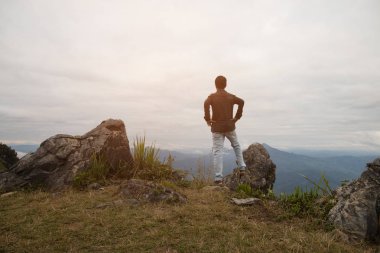 adam uçurumun üzerinde duran ve vadi ve dağ bakıyor