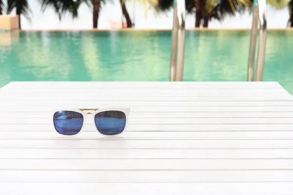 Gafas de sol junto a la piscina — Foto de Stock