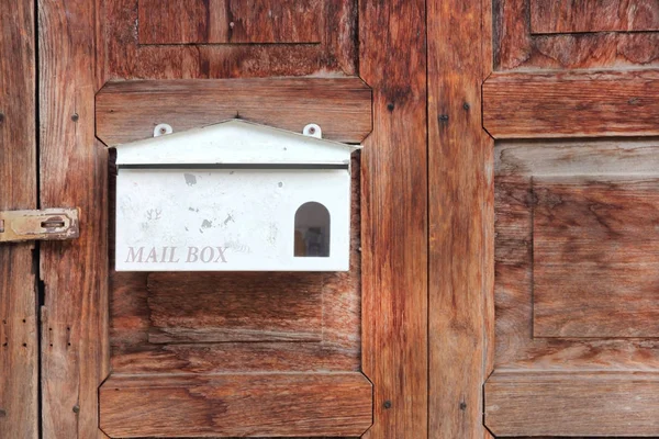 Eski ahşap kapıdaki beyaz posta kutusu. — Stok fotoğraf