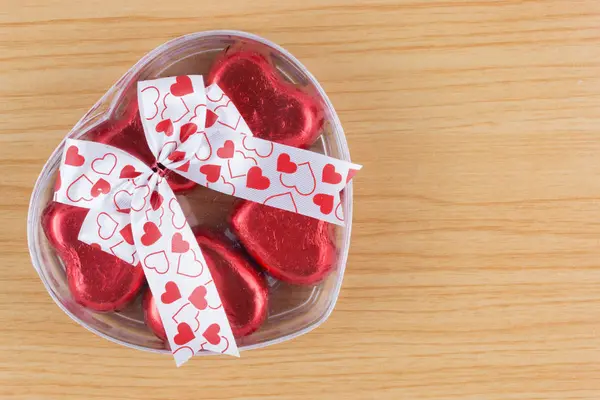 Шоколадные конфеты красное сердце в подарочной коробке с лентой на деревянной спине — стоковое фото