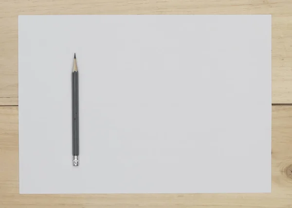 Bleistift und weißes Papier auf Holzgrund. — Stockfoto