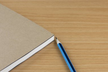 ahşap masa üzerinde defter ve kalem. 