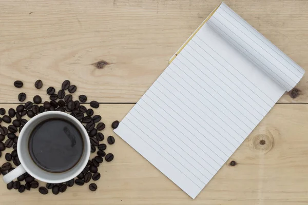 Kaffee und Notizbuch auf Holztisch — Stockfoto
