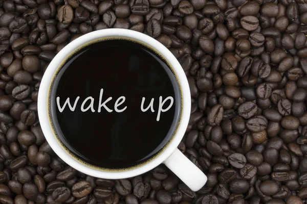 Despertar texto en la taza de café en el fondo granos de café — Foto de Stock