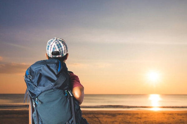 Молодой человек путешественник с рюкзаком на пляже, концепция путешествия.