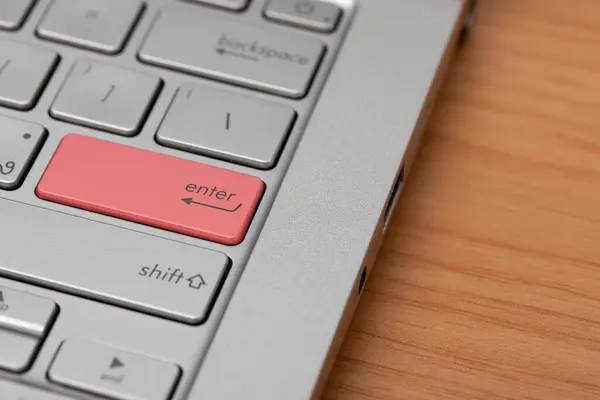 Close-up of a red enter button on the keyboard.