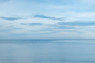 Güzel bir manzara, sakin bir denizin üzerindeki mavi gökyüzü, Tayland. Sakin su yüzeyinin sakin deniz uyumu. Güneşli gökyüzü ve mavi okyanus.