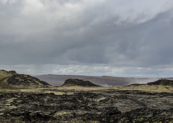 Dramatic landscape with dry stiff black lava, still steaming in Krafla volcanic caldera and fissure zone, Myvatn region. Popular tourist destination of Diamond circle in north of Iceland, Europe