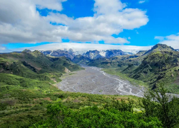 Breathtaking landscape of green valley of Thorsmork, with volcanoes, glaciers, green forest and blue sunny sky in summer day on Laugavegur and Fimmvorduhals trails cross point, Highlands of Iceland