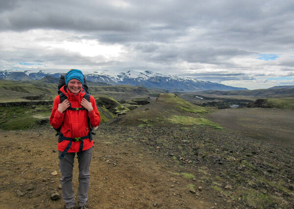 Young happy experienced hiker girl with heavy backpack enjoying the view on Laugavegur hiking trail from Thorsmork to Landmannalaugar, Iceland Travel Lifestyle wanderlust adventure concept