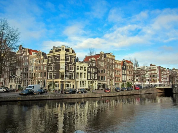 Kanałem miejskim i słynny holenderski flamandzki tradycyjne cegły budynki w Amsterdam, Holandia, Holandia — Zdjęcie stockowe