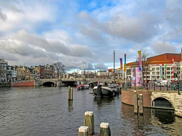 Canale della città con barche e famosi edifici in mattoni fiamminghi tradizionali olandesi ad Amsterdam, Olanda, Paesi Bassi — Foto Stock