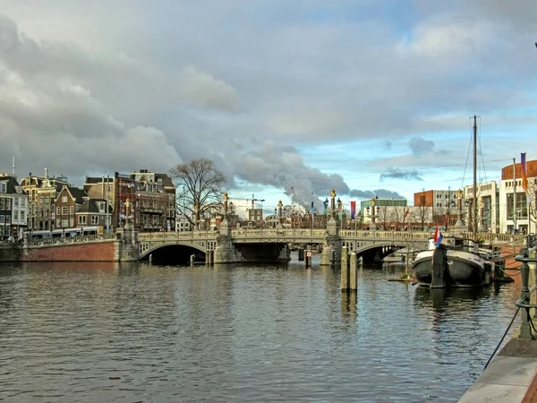 Bateau, pont et Amsterdam célèbres bâtiments traditionnels néerlandais en brique flamande à Amsterdam, Hollande, Pays-Bas — Photo