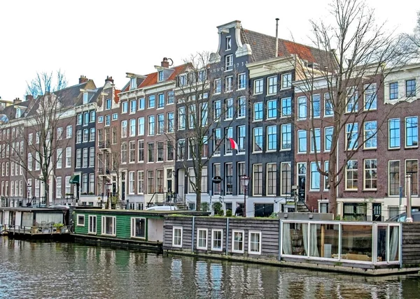 Рефлексия знаменитых амстердамских зданий с традиционным душем Флемиш брик, городской канал в Голландии, Нидерланды — стоковое фото