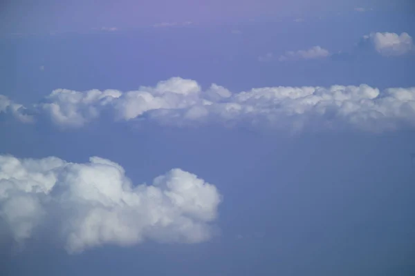 Luftaufnahme aus dem Flugzeugfenster mit blauem Himmel und weißen Wolken — Stockfoto