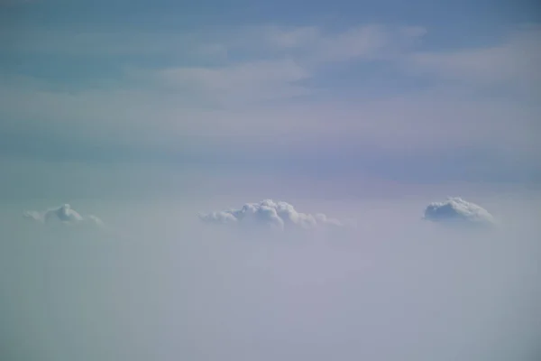 Luchtfoto van vliegtuig venster met blauwe hemel en witte wolken — Stockfoto