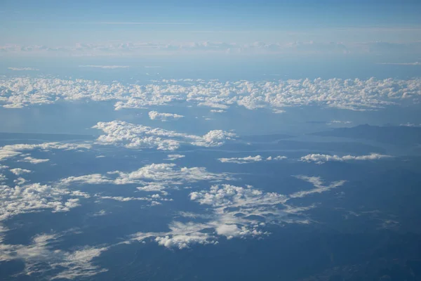 青空と白い雲を持つ平面窓からの航空写真 — ストック写真