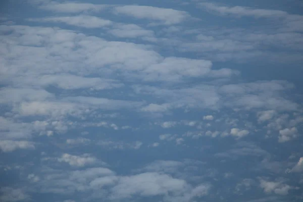 Luchtfoto van vliegtuig venster met blauwe hemel en witte wolken — Stockfoto