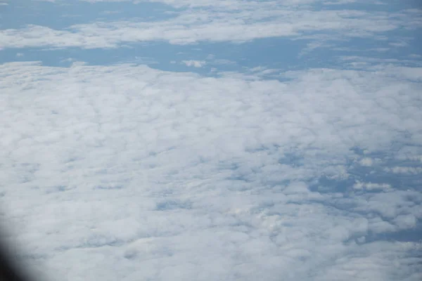 青空と白い雲を持つ平面窓からの航空写真 — ストック写真