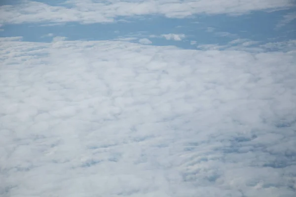 青空と白い雲を持つ平面窓からの航空写真 — ストック写真