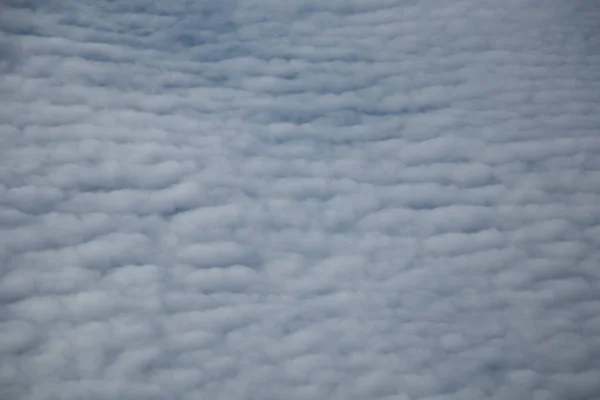 Aerial view from plane window with blue sky and white clouds — Stock Photo, Image