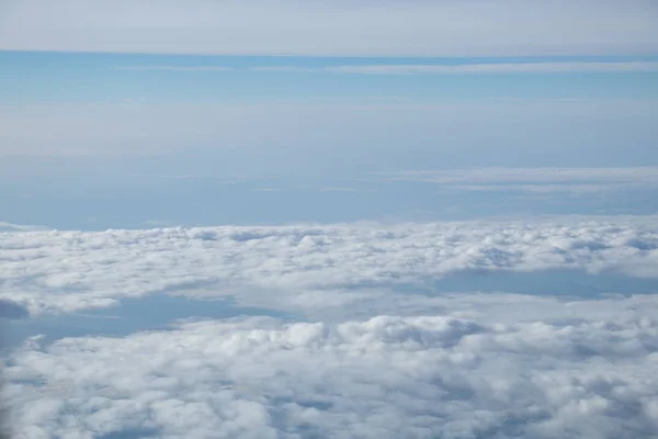 Luftaufnahme aus dem Flugzeugfenster mit blauem Himmel und weißen Wolken — Stockfoto