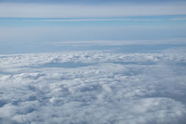 Luftaufnahme aus dem Flugzeugfenster mit blauem Himmel und weißen Wolken — Stockfoto