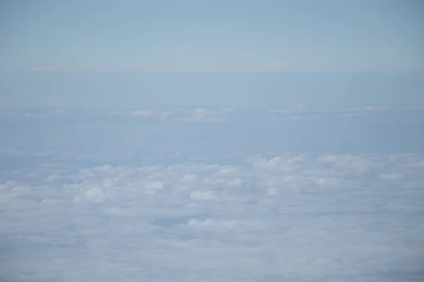 Luftaufnahme aus dem Flugzeugfenster mit blauem Himmel und weißen Wolken — Stockfoto