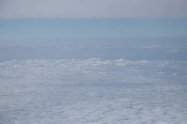 Pandangan udara dari jendela pesawat dengan langit biru dan awan putih — Stok Foto