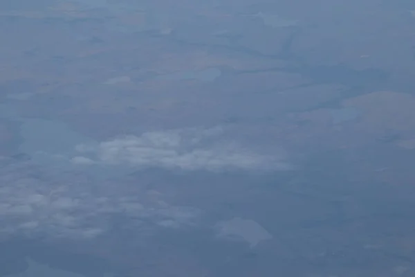푸른 하늘과 흰색 구름이있는 비행기 창에서 공중보기 — 스톡 사진