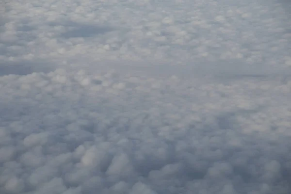 Luftaufnahme aus dem Flugzeugfenster mit blauem Himmel und weißen Wolken — Stockfoto