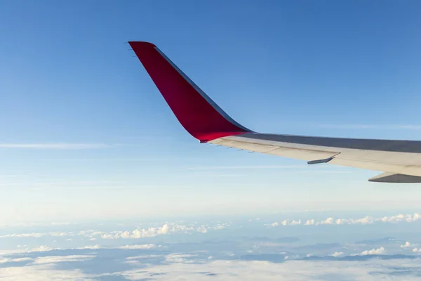 Wing of an airplane flying above the morning clouds and Andean mountain range — 스톡 사진