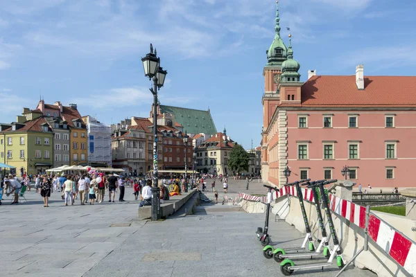 La gente que visita en la plaza del castillo, el castillo real una de las principales atracciones turísticas de Varsovia — Foto de Stock