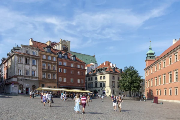 La gente que visita en la plaza del castillo, el castillo real una de las principales atracciones turísticas de Varsovia — Foto de Stock